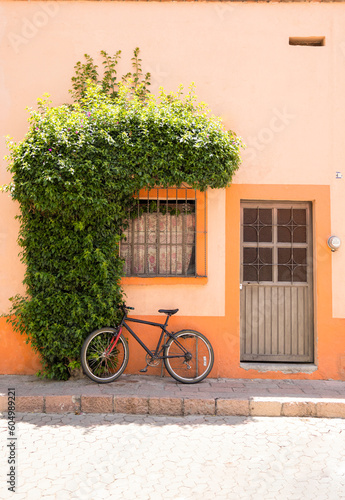 Bicicleta estacionada en fachada de casa naranja