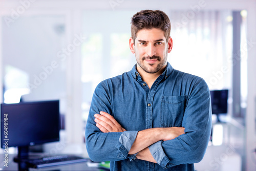 Caucasian professional man standing with arms crossed at the office