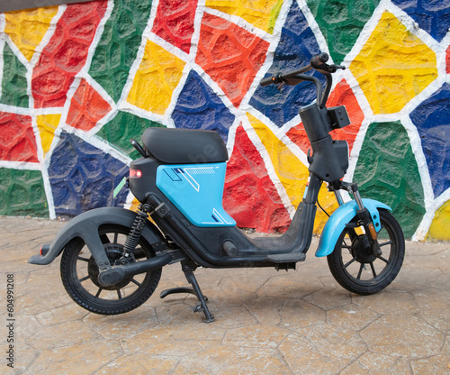 An electric scooter parked on a sidewalk