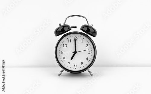 Black alarm clock on white wall background