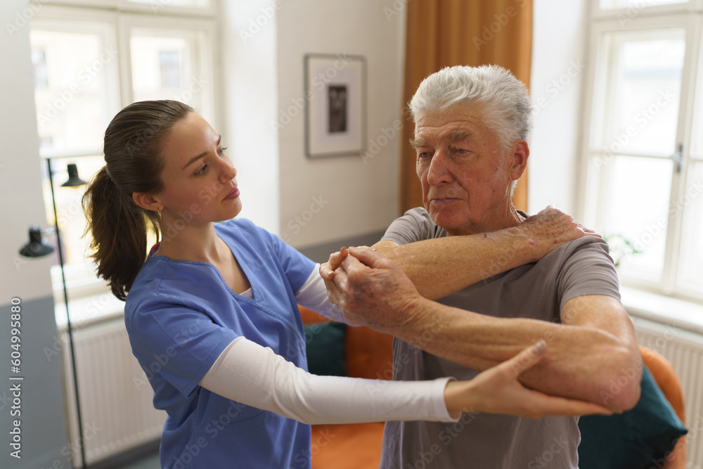 Obraz premium Young nurse doing exercise with senior man.