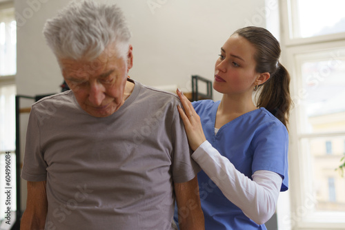 Young nurse doing exercise with senior man.