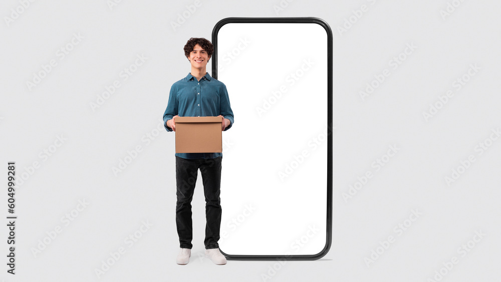 Man Holding Cardboard Box Near Huge Phone On White Background Man Holding Cardboard Box Near Huge Phone On White Background
