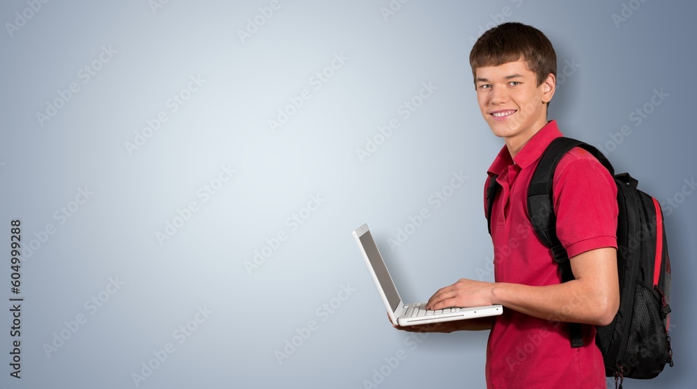 Young happy teenager student  holding laptop