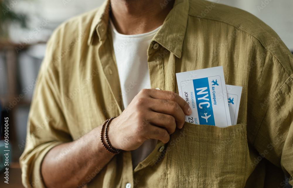 Close up of man with plane tickets in his pocket, travel agency concept. - obrazy, fototapety, plakaty 