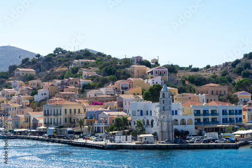 Clock Tower and houses of island Symi or Simi, Greek mountainous island and municipality, part of Dodecanese island chain. Harbor town of Symi and adjacent upper town Ano Symi