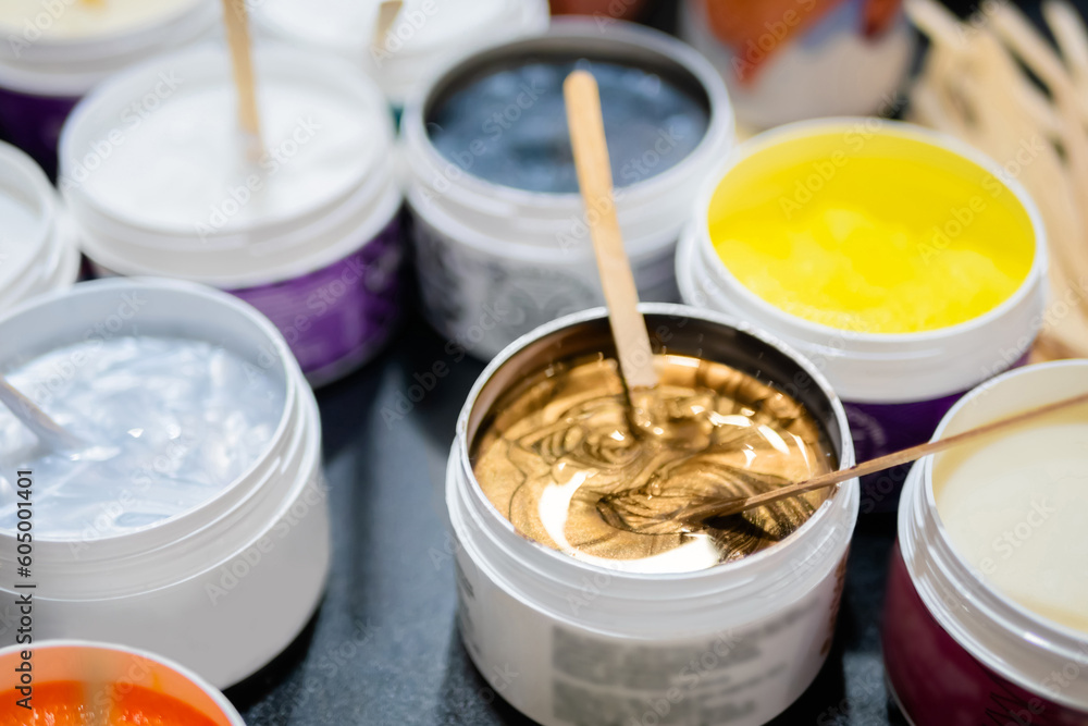 Set of jars with cosmetics body cream with wooden stick on counter of cosmetic store. Treatment, care and wellness concept Set of jars with cosmetics body cream with wooden stick on counter of cosmetic store. Treatment, care and wellness concept
