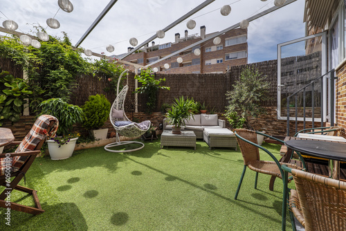 Quadro em tela A wonderful urban terrace with lots of neat plants, wooden seats, a swing