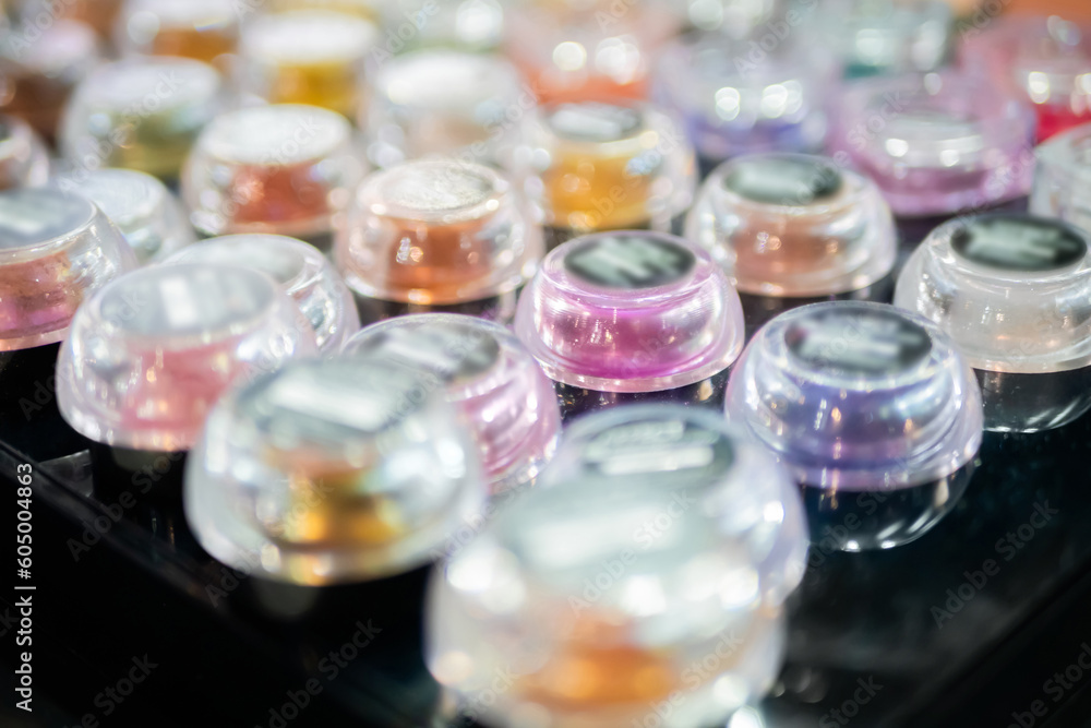 Transparent jars with mineral eyeshadow in row on counter for sale in makeup store, exhibition. Glamour, fashion, make up, beauty and skincare concept Transparent jars with mineral eyeshadow in row on counter for sale in makeup store, exhibition. Glamour, fashion, make up, beauty and skincare concept