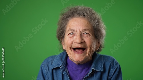 Foto Closeup portrait of toothless elderly senior old woman with wrinkled skin and grey hair getting great happy with success winner isolated on green screen background