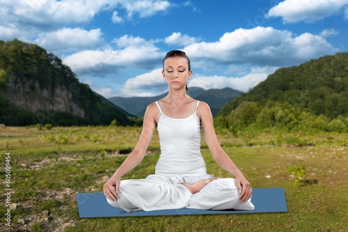 Happy young woman meditating on outdoor background