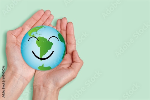 Hands holding a globe of earth with cute smile face