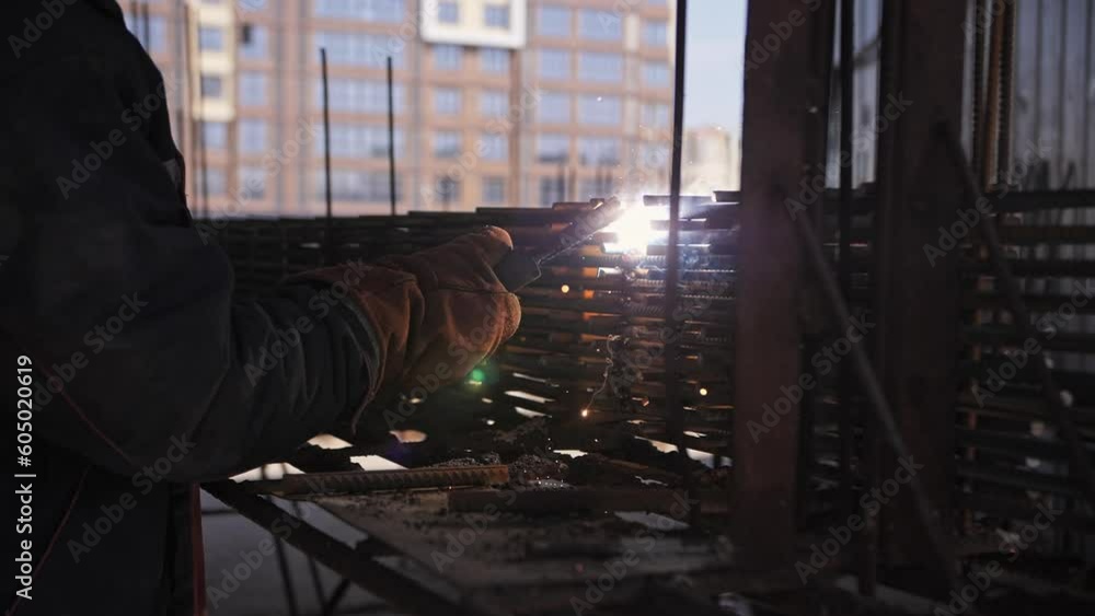Welder works at a construction site. Sparks and smoke fly Welder works at a construction site. Sparks and smoke fly