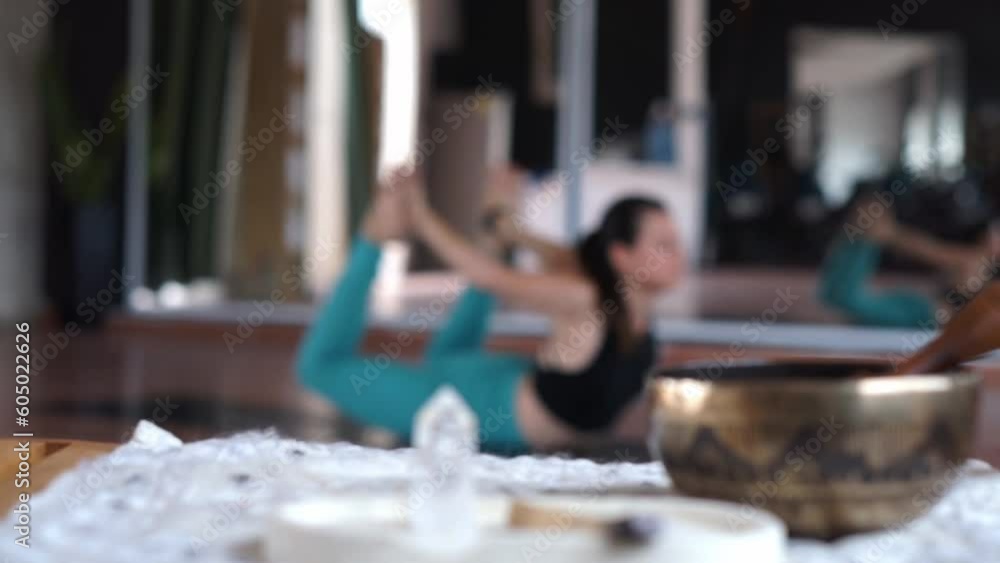 An altar on a table and a person in the background performing a yoga posture. An altar on a table and a person in the background performing a yoga posture.