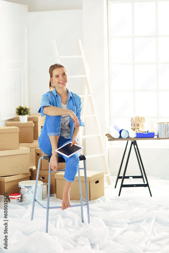 Young woman sitting at home and buying new furniture over the Internet using a tablet computer Young woman sitting at home and buying new furniture over the Internet using a tablet computer