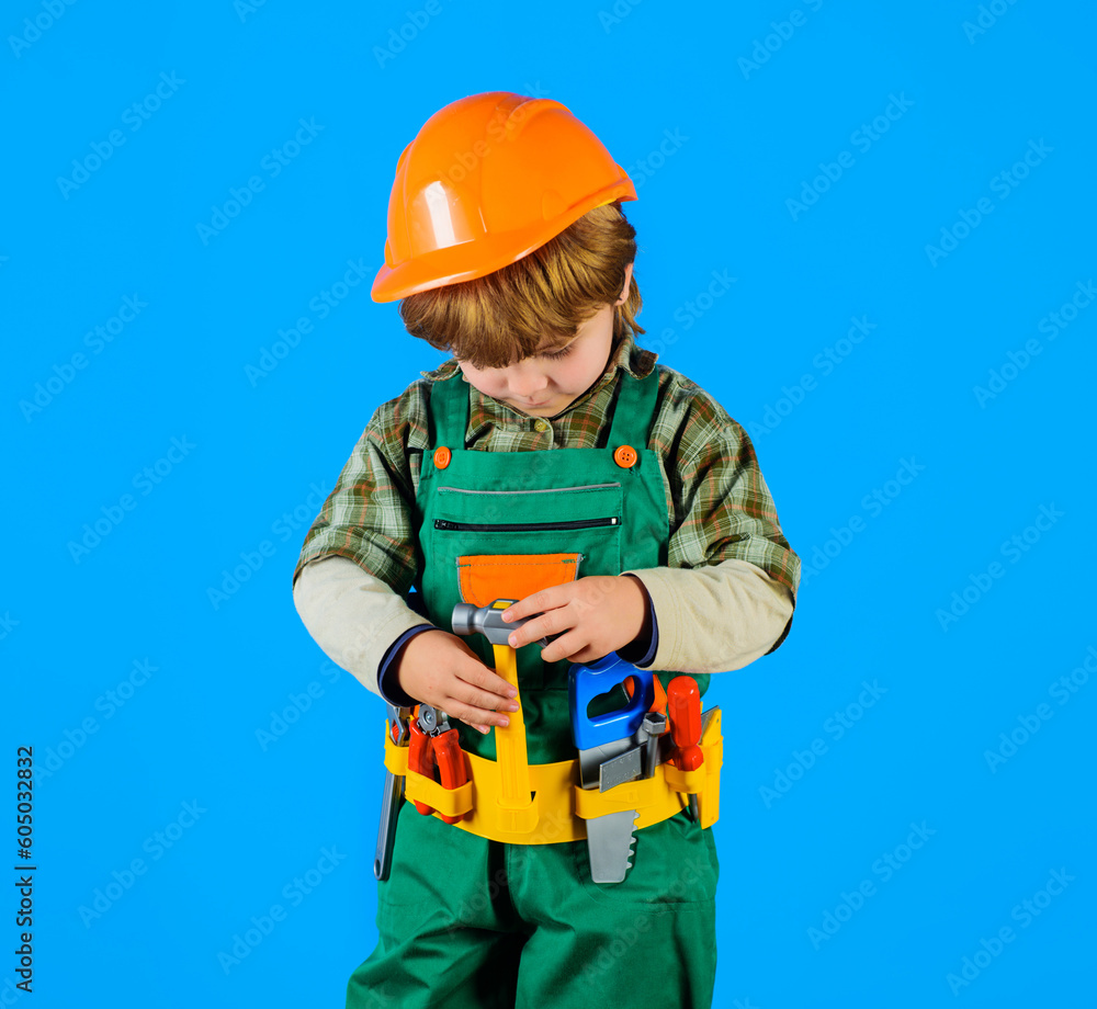 Little kid repairman with toolbelt. Tools for building. Builder boy in safety helmet and toy tools for repair. Little child in builder's uniform with tool belt. Work with tools. Child game. Repair. Little kid repairman with toolbelt. Tools for building. Builder boy in safety helmet and toy tools for repair. Little child in builder's uniform with tool belt. Work with tools. Child game. Repair.