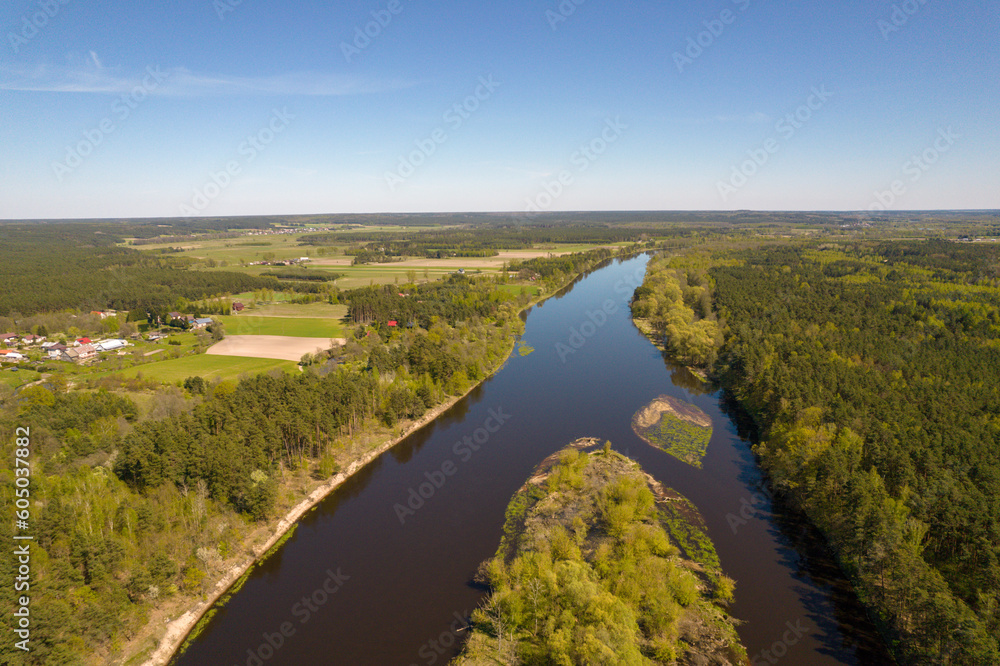 The Bug River in Drochiczyn. View of the escarpment with the city. Forest, trees. Day.