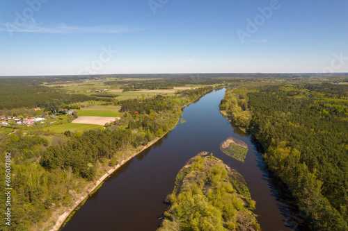 The Bug River in Drochiczyn. View of the escarpment with the city. Forest  trees. Day.