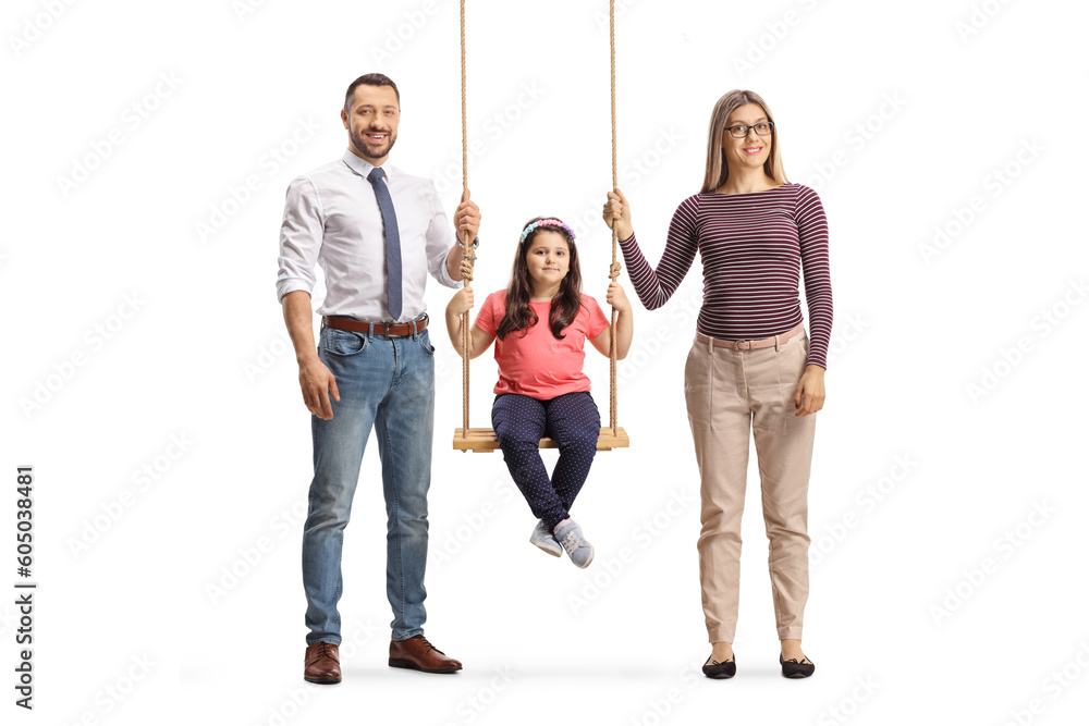 Fototapeta premium Mother and father standing next to girl on a wooden swing
