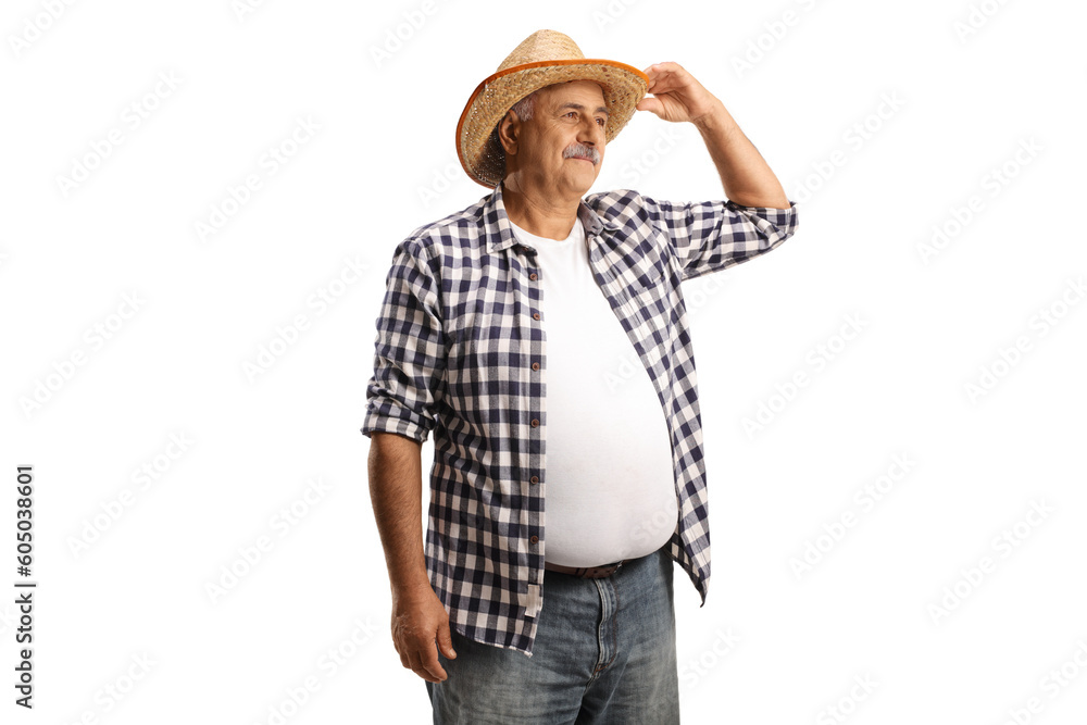 Mature farmer with a straw hat looking in distance Mature farmer with a straw hat looking in distance