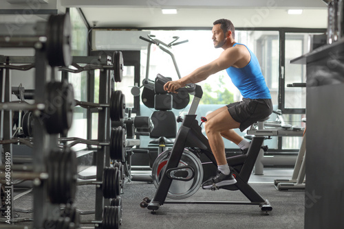 Man exercising cardio training in a gym on a stationary bicycle