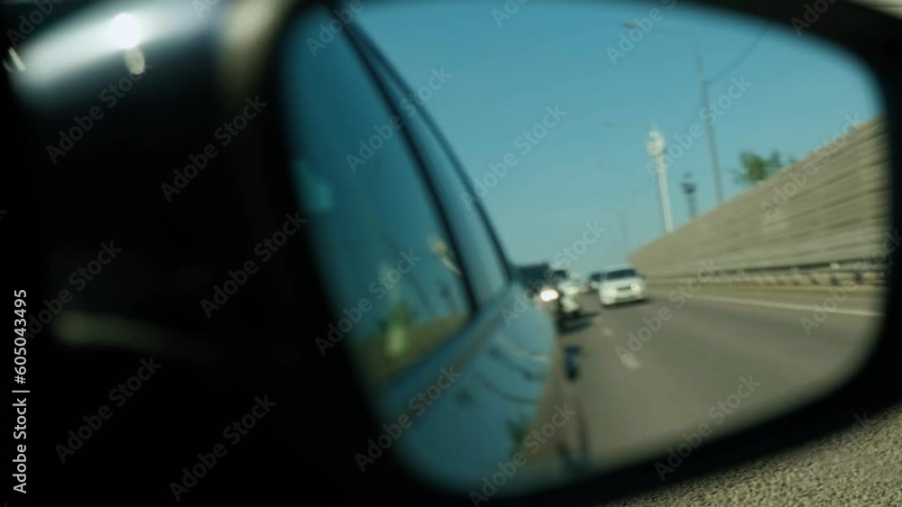 View from the reflection of the side mirror. Blured Cars are driving on the road in the next lane on a sunny day. View from the reflection of the side mirror. Blured Cars are driving on the road in the next lane on a sunny day.