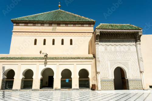 A mosque with arabic architecture and moorish arches at a plaza in Marrakech, Morocco