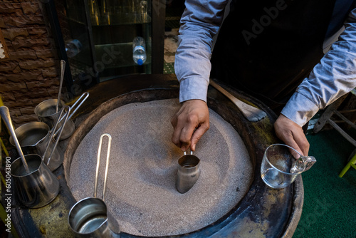 Fototapeta Naklejka Na Ścianę i Meble -  Turkish traditional method of making coffee with boiling hot sand in the streets of the Marrakech Medina in Morocco