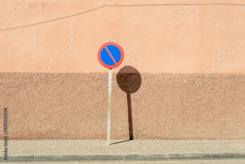 Blue and red stop sign with a background erath tone colors divided half brown and half pink in the streets of the Marrakech Medina in Morocco photo