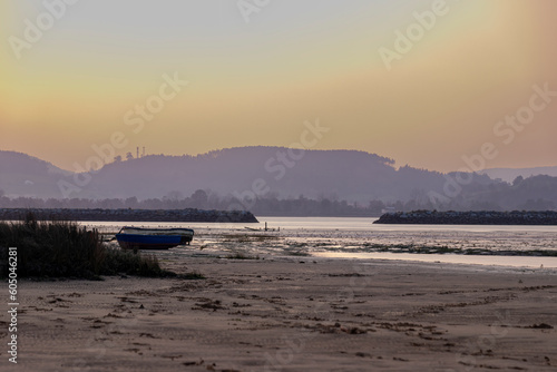 Coastal Tranquility: Embracing the Beauty of Sunset with Two Boats on Laredo's Sandy Beach