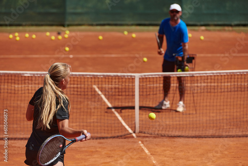 A professional tennis player and her coach training on a sunny day at the tennis court. Training and preparation of a professional tennis player © .shock
