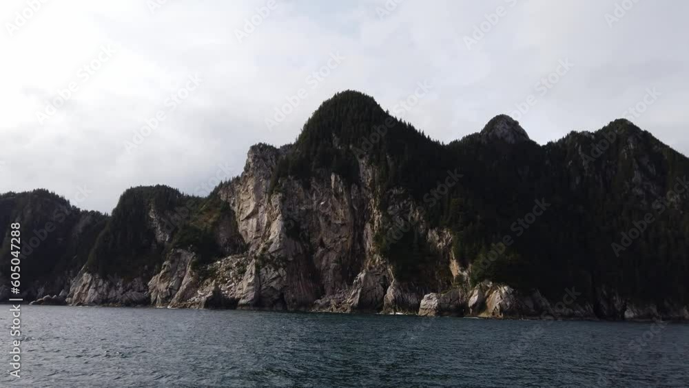 Blue waters and tree covered rocks at Kenai Fjords National Park, Alaska Blue waters and tree covered rocks at Kenai Fjords National Park, Alaska