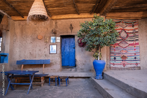 Inside a traditional berber house in the mountains of the Ourika Valley in Morocco with a persian rug and a stool photo