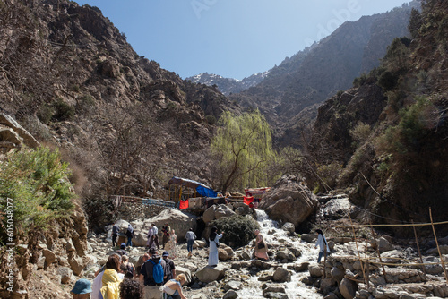 People walking up the hills of the Ourika Valley across the river down from the mountains