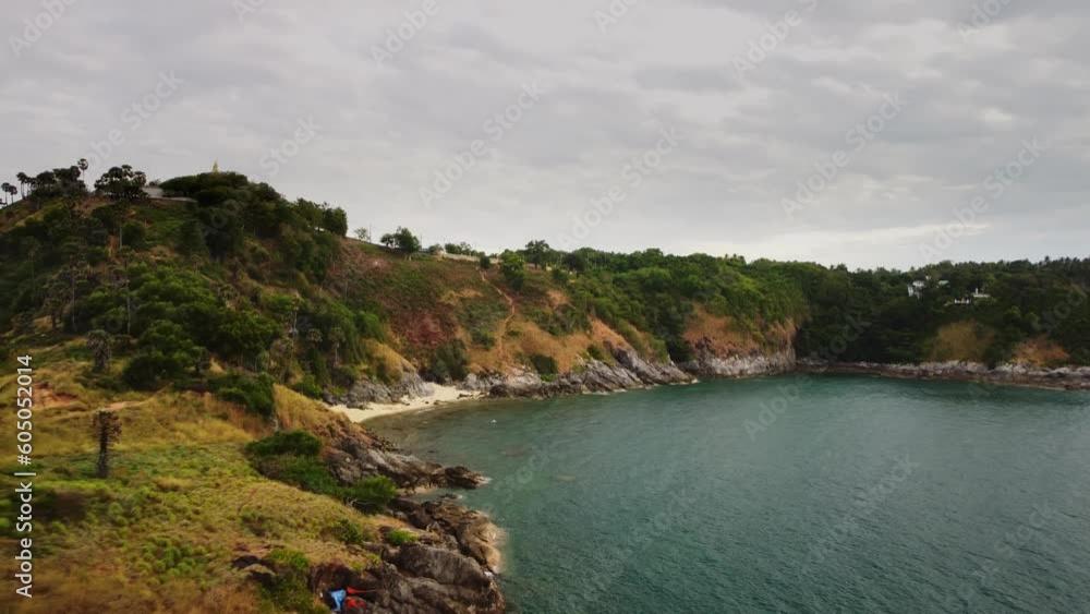 Rocky coast and cape are washed by sea waves filmed in Phuket by drone. Aerial footage of island with green hills surrounded by ocean. Enjoying beauty of Asian nature. Empty harbor and wild shore Rocky coast and cape are washed by sea waves filmed in Phuket by drone. Aerial footage of island with green hills surrounded by ocean. Enjoying beauty of Asian nature. Empty harbor and wild shore