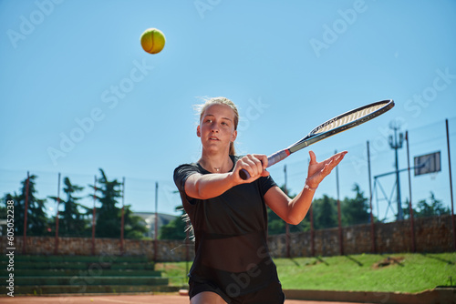 A young girl showing professional tennis skills in a competitive match on a sunny day, surrounded by the modern aesthetics of a tennis court. © .shock