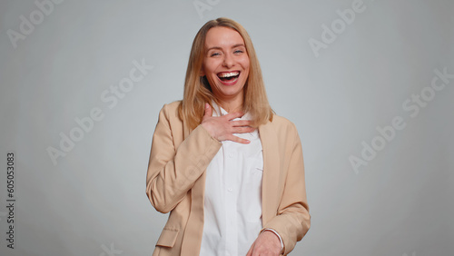 Amused office secretary woman looking to camera, laughing out loud, taunting making fun of ridiculous appearance, funny joke anecdote. Business girl isolated alone on gray studio background