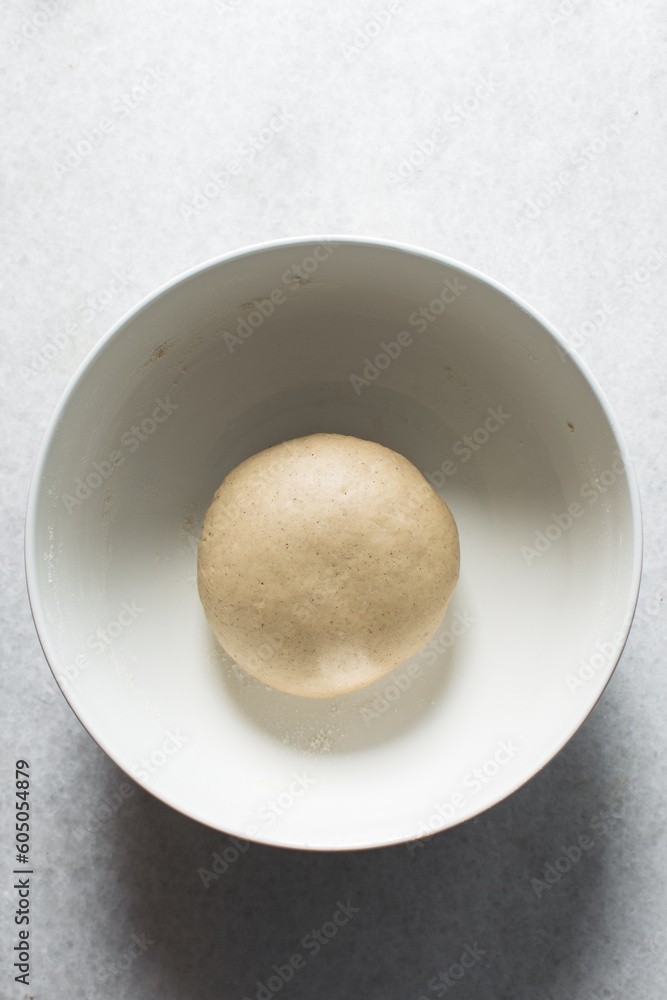 Pastry dough resting in a white bowl, process of making Swedish cinnamon buns or homemade Kanelbullar Pastry dough resting in a white bowl, process of making Swedish cinnamon buns or homemade Kanelbullar