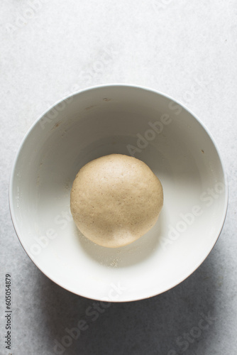 Pastry dough resting in a white bowl, process of making Swedish cinnamon buns or homemade Kanelbullar