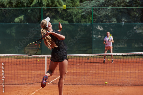 Young girls in a lively tennis match on a sunny day, demonstrating their skills and enthusiasm on a modern tennis court.