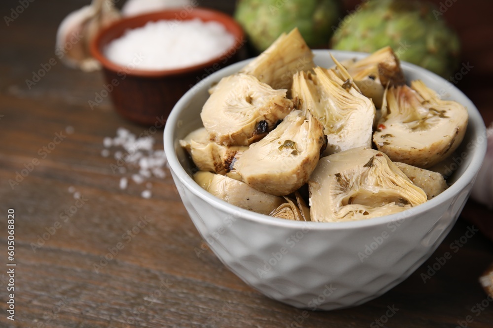 Bowl of pickled artichokes on wooden table, closeup Bowl of pickled artichokes on wooden table, closeup