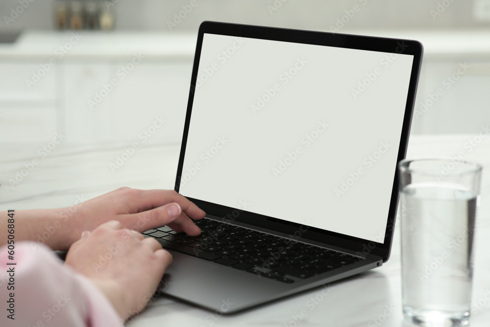 Woman using laptop at white table indoors, closeup Woman using laptop at white table indoors, closeup