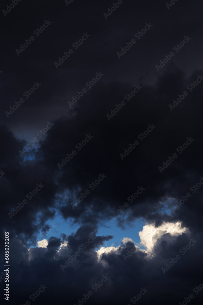 Epic Storm sky, dark grey black and white rain cumulus clouds with blue sky background texture Epic Storm sky, dark grey black and white rain cumulus clouds with blue sky background texture