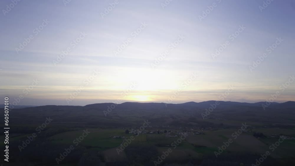 Dramatic Scene Of Countryside Farm And Mountains During Sunset Near Lyon In Auvergne-Rhône-Alpes, France. Aerial Wide Shot Dramatic Scene Of Countryside Farm And Mountains During Sunset Near Lyon In Auvergne-Rhône-Alpes, France. Aerial Wide Shot