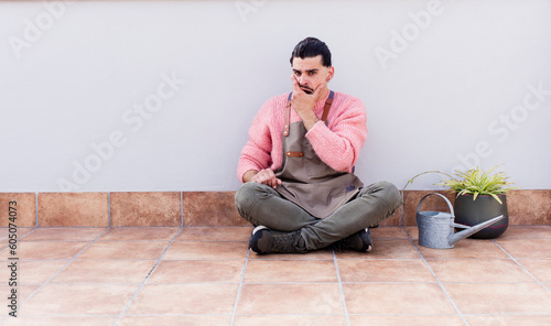 young handsome man gardering and sitting on the floor outdoors © kues1