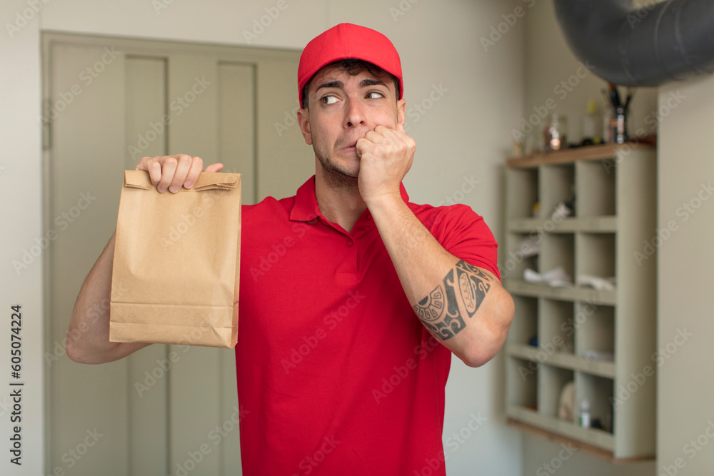 young handsome man feeling scared, worried or angry and looking to the side. delivery man concept young handsome man feeling scared, worried or angry and looking to the side. delivery man concept