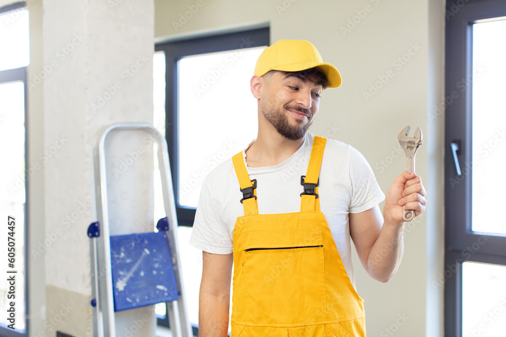 young handsome man smiling and looking with a happy confident expression. handyman concept young handsome man smiling and looking with a happy confident expression. handyman concept