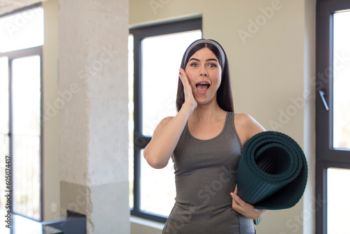 pretty young woman feeling happy and astonished at something unbelievable. yoga concept