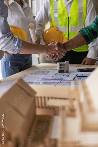 Professional Asian male engineer shaking hands with male architect after meeting to build modern building. Professional team in industry and concept of engineers.
