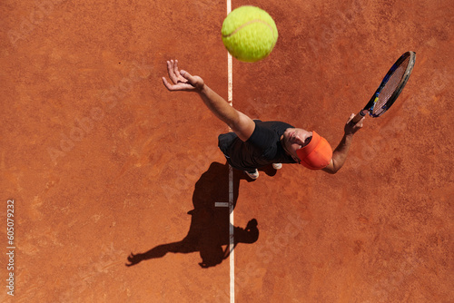 Top view of a professional tennis player serves the tennis ball on the court with precision and power © .shock